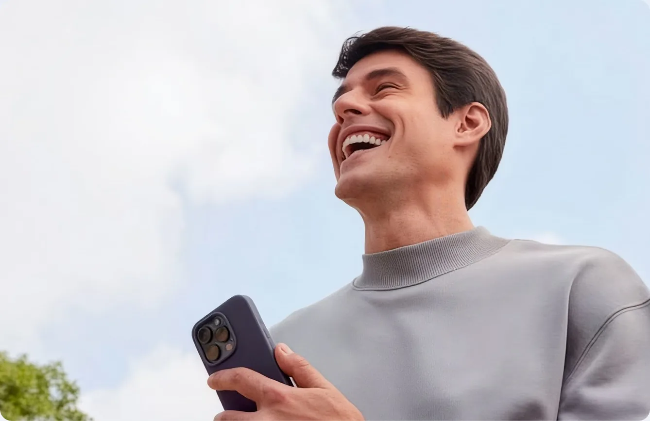 Person smiling with a phone in hand