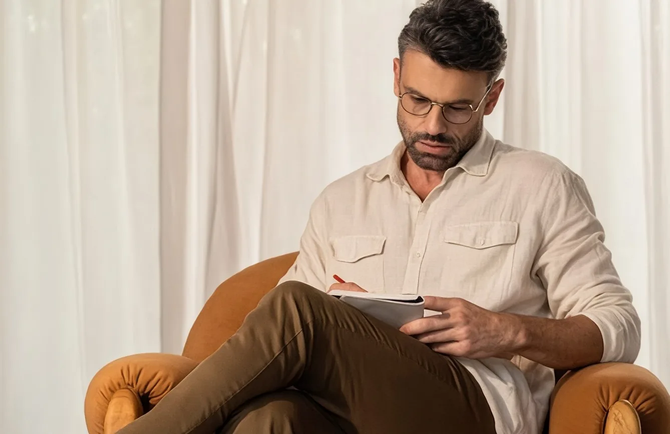 Hombre revisando documentos de obra en un sillón